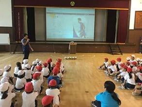 Shining Arcs player giving a presentation to students during a class