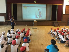 Shining Arcs player giving a presentation to students during a class
