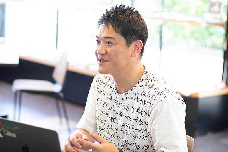 堀江健太郎さん。株式会社ATOMica事業開発グループ。東京都出身で、大学卒業後は経営コンサルタント会社に就職。その後、旅行系スタートアップを立ち上げ、コロナ禍に売却し、深谷市に移住。地域通貨negiのシステム開発に携わる。2024年7月から現職