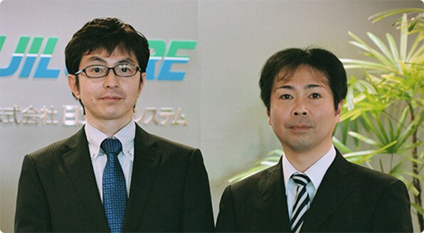 昇降機保全事業部 保全技術部 係長 深井 久徳氏(写真左) 技術開発本部 ビルシステム開発部 主任 酒井 亮一氏(写真右)
