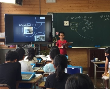 本市立楠小学校における授業風景。子どもたちがタブレットを活用し、課題に対して自分たちの考えをまとめ、率先して発表している。